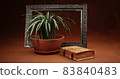 Pot with an old book and a picture frame 83840483