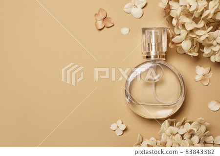 Women's perfume bottle mockup and dry hydrangea flowers on beige background. Natural earthy colors, copy space Women's perfume bottle mockup and dry hydrangea flowers on beige background. Natural earthy colors, copy space 83843382
