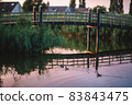 Wooden bridge and ducks in the canal in the evening 83843475