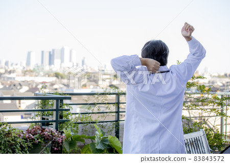 A young Japanese male doctor who changes his mood on the roof A young Japanese male doctor who changes his mood on the roof 83843572