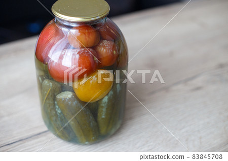 spoiled can of vegetable seaming. Glass jar with homemade pickled tomatos and cucumbers with white fungus spoiled can of vegetable seaming. Glass jar with homemade pickled tomatos and cucumbers with white fungus 83845708