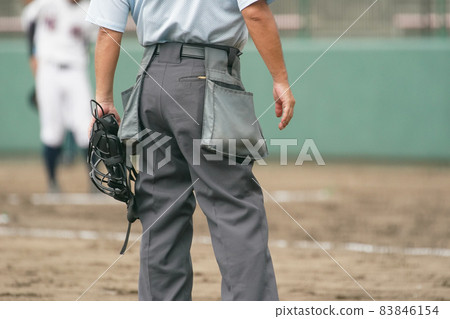 A ball umpire waiting for a pitcher's pitching practice during a baseball game A ball umpire waiting for a pitcher's pitching practice during a baseball game 83846154