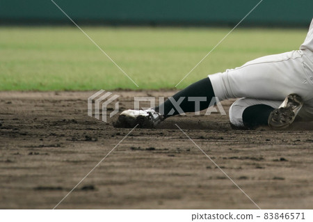 A baseball player trying to steal a base during a baseball game 83846571
