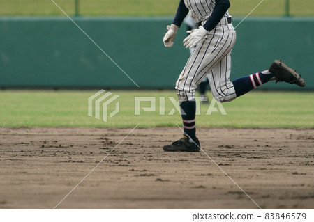 A baseball player trying to steal a base during a baseball game 83846579