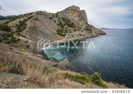 Summer Crimean landscape. Golitsyn trail at rocky Black Sea coast at sunny day, Novyi Svit, Sudak Municipality, Crimea 83846619