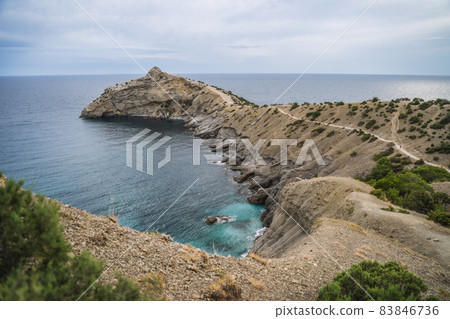 Cape Kapchik and Golitsyn trail at rocky Black Sea coast at sunny day, Novyi Svit, Sudak Municipality, Crimea Cape Kapchik and Golitsyn trail at rocky Black Sea coast at sunny day, Novyi Svit, Sudak Municipality, Crimea 83846736