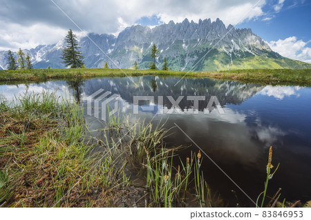 Mountain pond with Wilder Kaiser range reflecting in water pond, Tirol - Austria 83846953