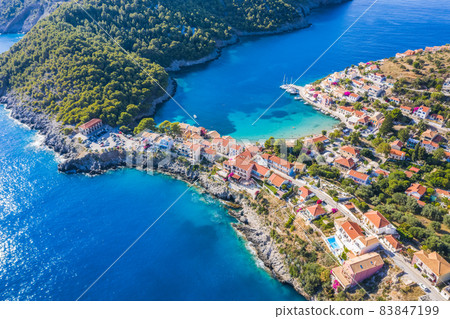 Assos picturesque fishing village from above, Kefalonia, Greece. Aerial drone view. Sailing boats moored in turquoise bay Assos picturesque fishing village from above, Kefalonia, Greece. Aerial drone view. Sailing boats moored in turquoise bay 83847199