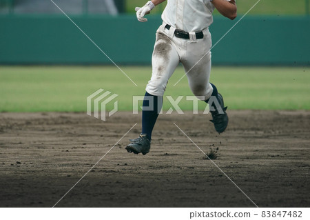 A baseball player who runs at full speed aiming for the next base during a baseball game 83847482