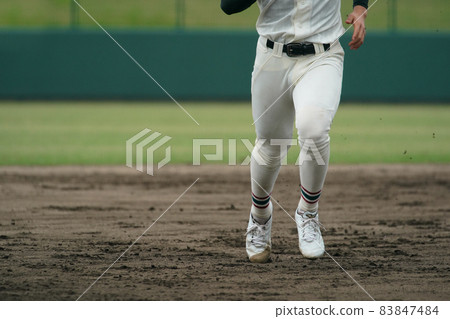 A baseball player who runs at full speed aiming for the next base during a baseball game 83847484