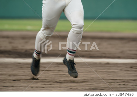 A baseball player who runs at full speed aiming for the next base during a baseball game A baseball player who runs at full speed aiming for the next base during a baseball game 83847486