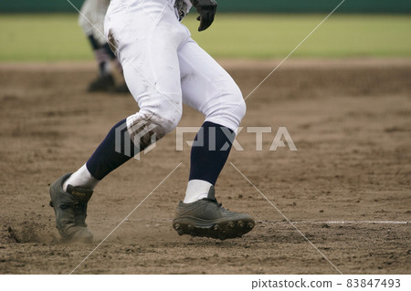 A baseball player who runs at full speed aiming for the next base during a baseball game 83847493