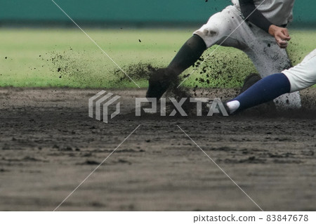 A fielder aiming for double play by touching a runner who tried to steal a base during a baseball game 83847678