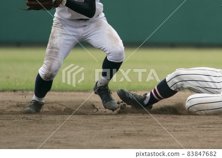 A fielder aiming for double play by touching a runner who tried to steal a base during a baseball game 83847682