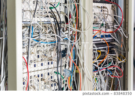 server room rack with tangled network cables creating messy unti 83848350