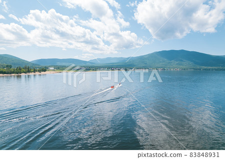 Summertime imagery of Lake Baikal is a rift lake located in southern Siberia, Russia Baikal lake summer landscape view from a cliff near Grandma's Bay. Drone's Eye View. 83848931