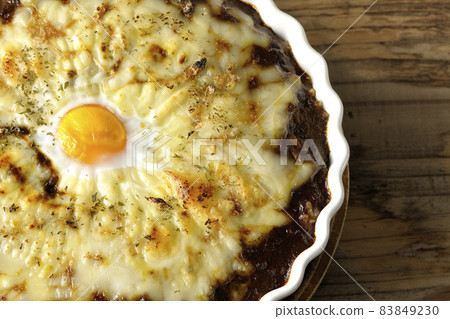 A bird's-eye view of grilled curry with plenty of melting cheese and eggs A bird's-eye view of grilled curry with plenty of melting cheese and eggs 83849230