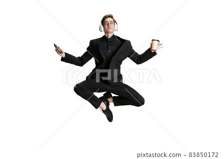 Young man in black business suit dancing isolated on white background. Art, motion, action, flexibility, inspiration concept. 83850172