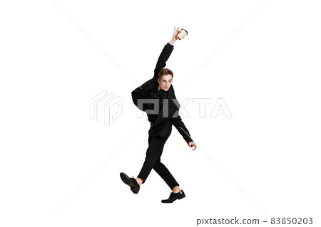 Young man in black business suit dancing isolated on white background. Art, motion, action, flexibility, inspiration concept. Young man in black business suit dancing isolated on white background. Art, motion, action, flexibility, inspiration concept. 83850203