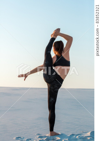 Fitness yoga woman stretching on sand. Fit female athlete doing yoga pose. Fitness yoga woman stretching on sand. Fit female athlete doing yoga pose. 83852321