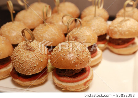 the Close up of appetizing mini beef hamburgers on at catering event. the Close up of appetizing mini beef hamburgers on at catering event. 83852398