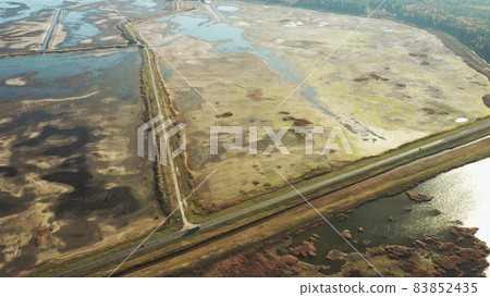 Aerial View Of Highway Road Through Ponds Autumn Landscape. Truck Tractor Unit Prime Mover Traction Unit In Motion On Freeway. Business Transportation. Top View, Drone View, Bird's Eye View Aerial View Of Highway Road Through Ponds Autumn Landscape. Truck Tractor Unit Prime Mover Traction Unit In Motion On Freeway. Business Transportation. Top View, Drone View, Bird's Eye View 83852435
