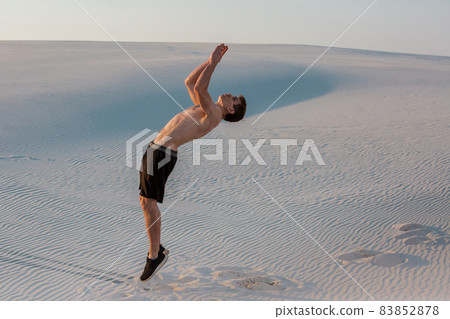 Man study parkour on their own. Acrobatics in the sand Man study parkour on their own. Acrobatics in the sand 83852878