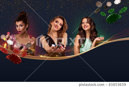 Three girls in smart dresses, jewelry. They holding chips, some of them flying, posing on blue background. Copy space for your text. Poker, casino Three girls in smart dresses, jewelry. They holding chips, some of them flying, posing on blue background. Copy space for your text. Poker, casino 83853639