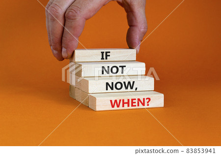 If not now, when symbol. Wooden blocks with words 'if not now, when'. Beautiful orange background. Businessman hand. Copy space. Business and motivational quote concept. 83853941