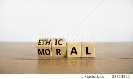 Ethical or moral symbol. Turned wooden cubes and changed the word 'moral' to 'ethical' on a beautiful wooden table, white background. Business and ethical or moral concept. Copy space. Ethical or moral symbol. Turned wooden cubes and changed the word 'moral' to 'ethical' on a beautiful wooden table, white background. Business and ethical or moral concept. Copy space. 83853953