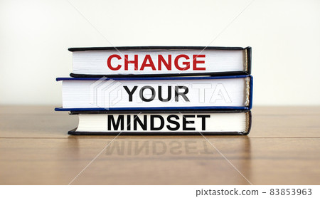 Books with text 'change your mindset' on beautiful wooden table, white background. Business concept. Copy space. 83853963