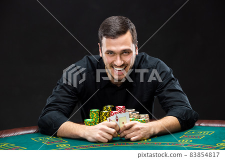 Happy poker player winning and holding a pair of aces 83854817