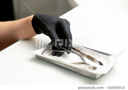 Professional manicure master prepares nail care tools on a white background with copy space. Professional manicure master prepares nail care tools on a white background with copy space. 83856913