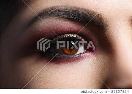 Bright pink professional makeup on eyes of woman closeup Bright pink professional makeup on eyes of woman closeup 83857834