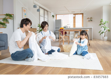 小學生和爸爸在家裡的客廳幫媽媽疊衣服 83857883