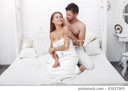 Couple lying on a bed in a room 83857905