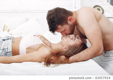 Couple lying on a bed in a room 83857919