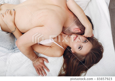 Couple lying on a bed in a room 83857923
