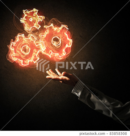 Concept of teamworking or organization presented by fire glowing cogwheels 83858308
