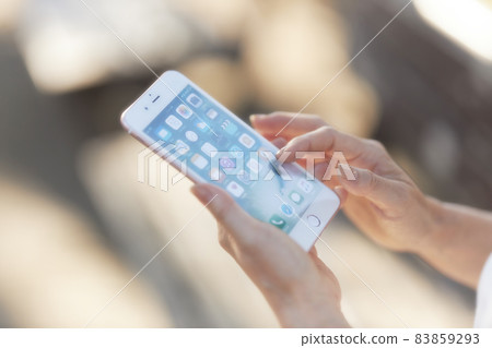 Hands of middle-aged women who use smartphones outdoors 83859293