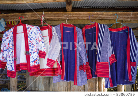 Colorful mountaineer shirts hanging on wooden rack. Colorful mountaineer shirts hanging on wooden rack. 83860789