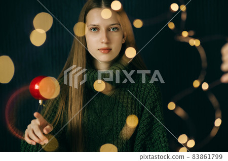 Beautiful teenager girl twists Christmas red ball on her finger 83861799
