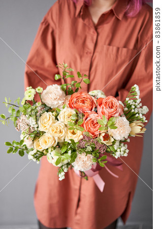 Beautiful bouquet of mixed flowers in woman hand. Floral shop concept . Beautiful fresh cut bouquet. Flowers delivery 83861859