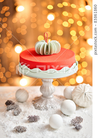 Mousse cake covered with red velour. Garland lamps bokeh on background. Modern european cake. French cuisine. Christmas theme. Copy space 83861860