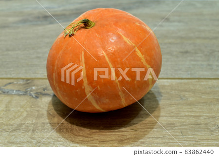 Small yellow pumpkin on a wooden background. 83862440