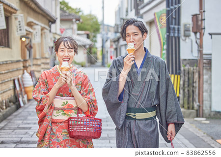 A young couple eating and walking in Mamedamachi, Hita City 83862556