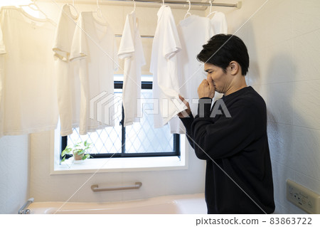 一個聞到浴室里幹了的襯衫的男人 一個聞到浴室里幹了的襯衫的男人 83863722