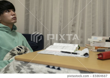 A man studying with a kotatsu A man studying with a kotatsu 83864687