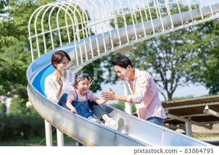 Young family playing on the slide 83864795