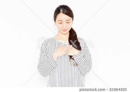 一個穿著休閒服的女人,雙手放在胸前 一個穿著休閒服的女人,雙手放在胸前 83864895